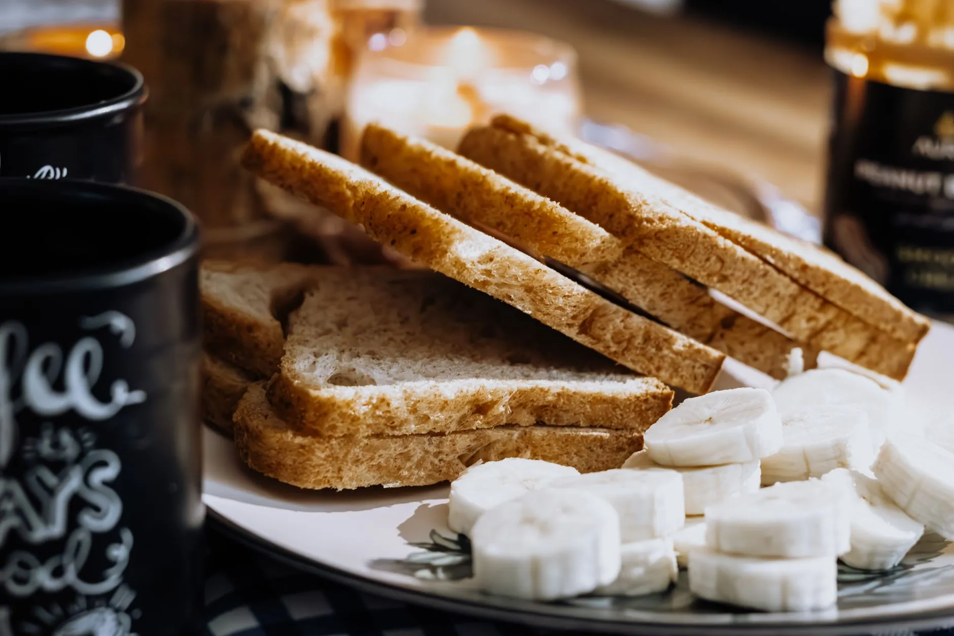 Warm breakfast scene with sliced bread, bananas, and coffee, evoking a cozy morning vibe.