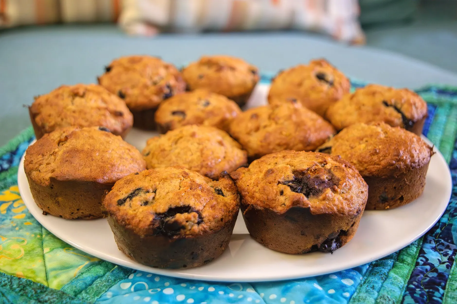 Freshly baked muffins on a white plate, perfect for breakfast or snacks.