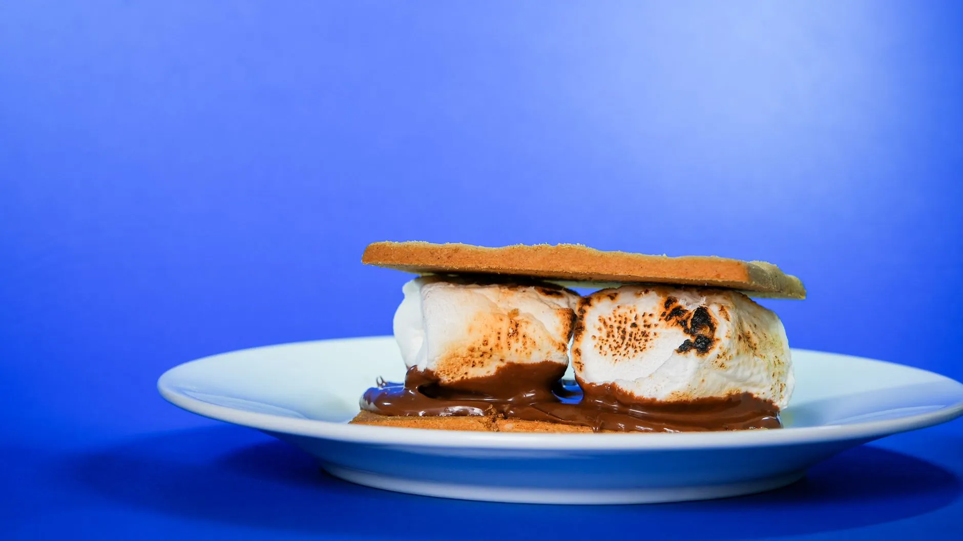 Close-up of a classic s'mores dessert with melted chocolate and toasted marshmallows.
