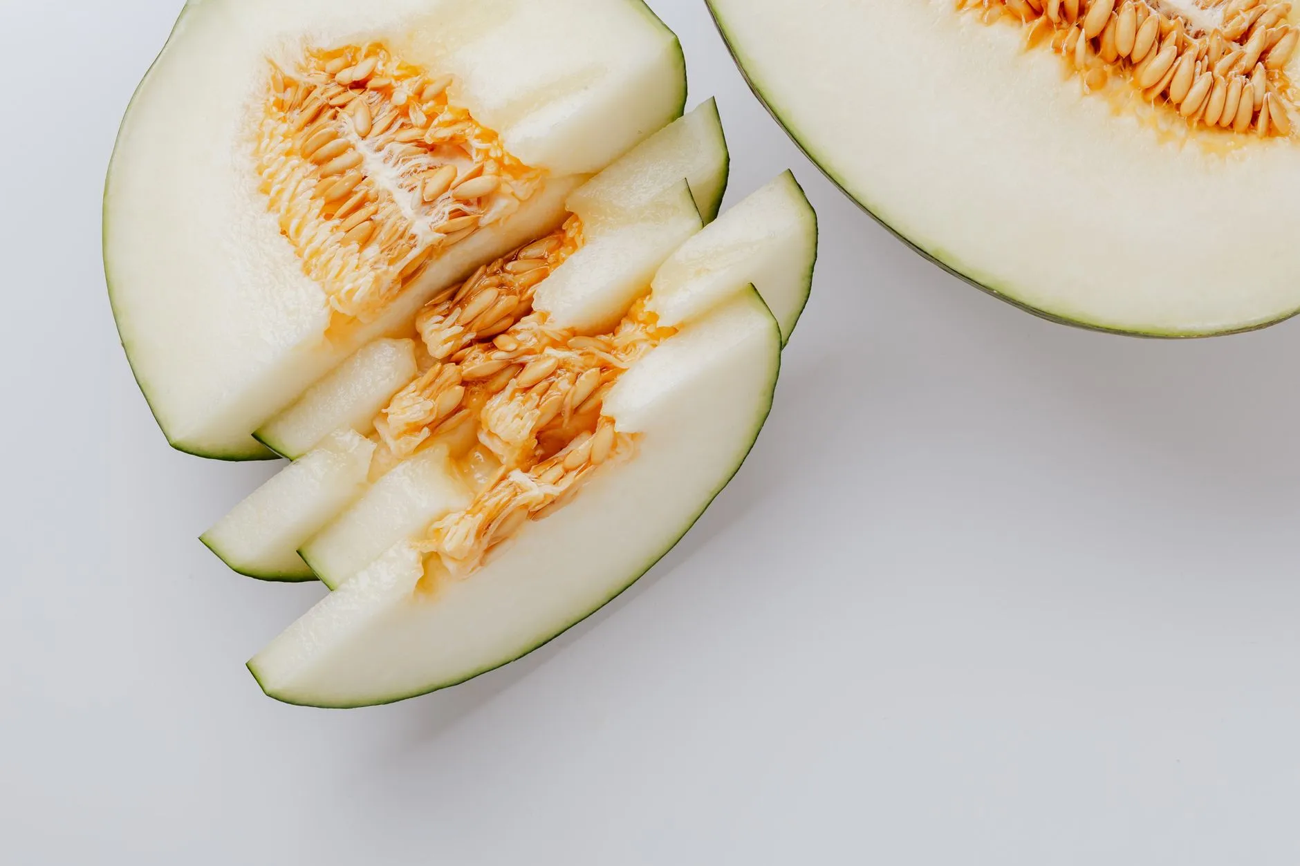 Close-up of fresh honeydew melon slices showcasing tasty seeds and vibrant texture.