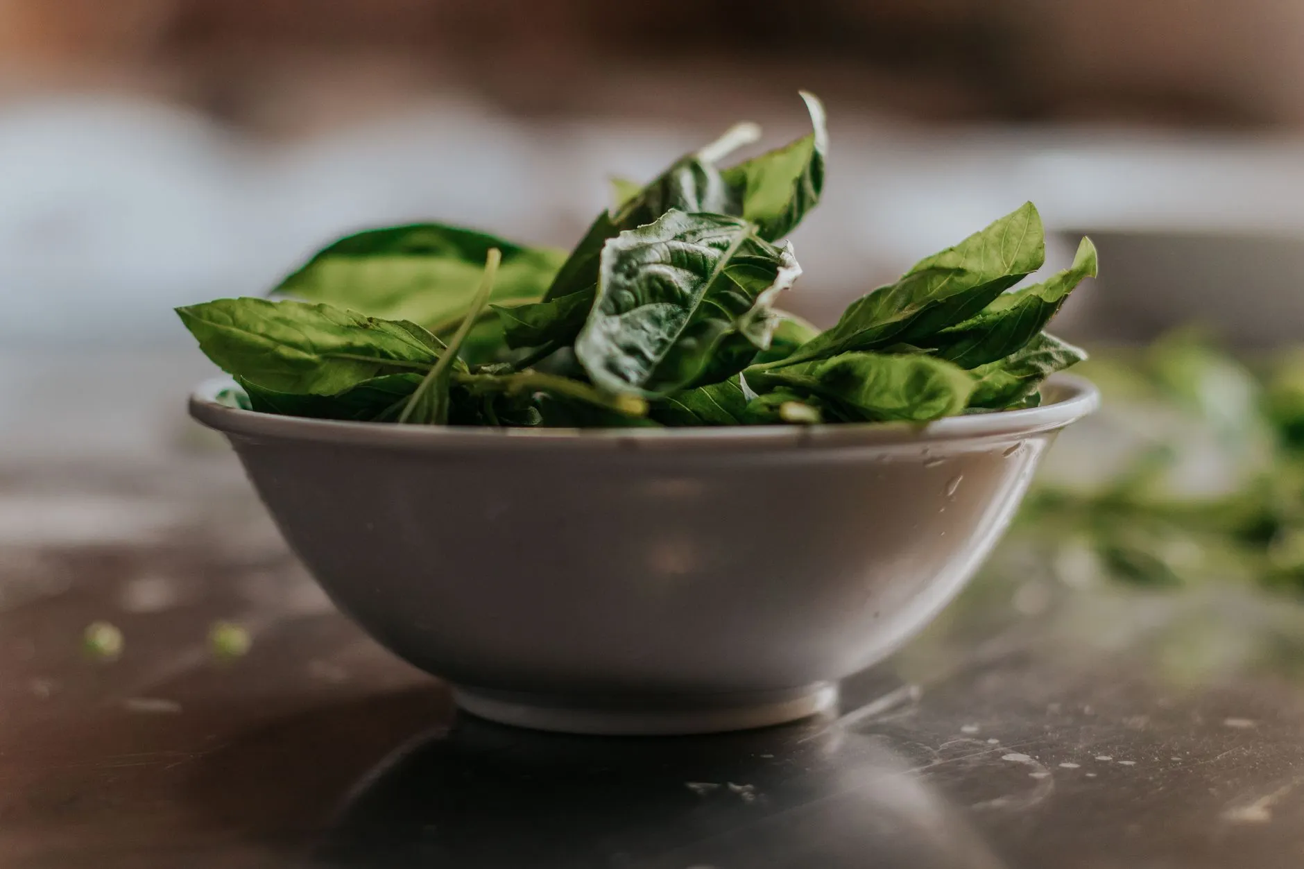 Close-up of fresh spinach leaves in a ceramic bowl, perfect for healthy eating themes.